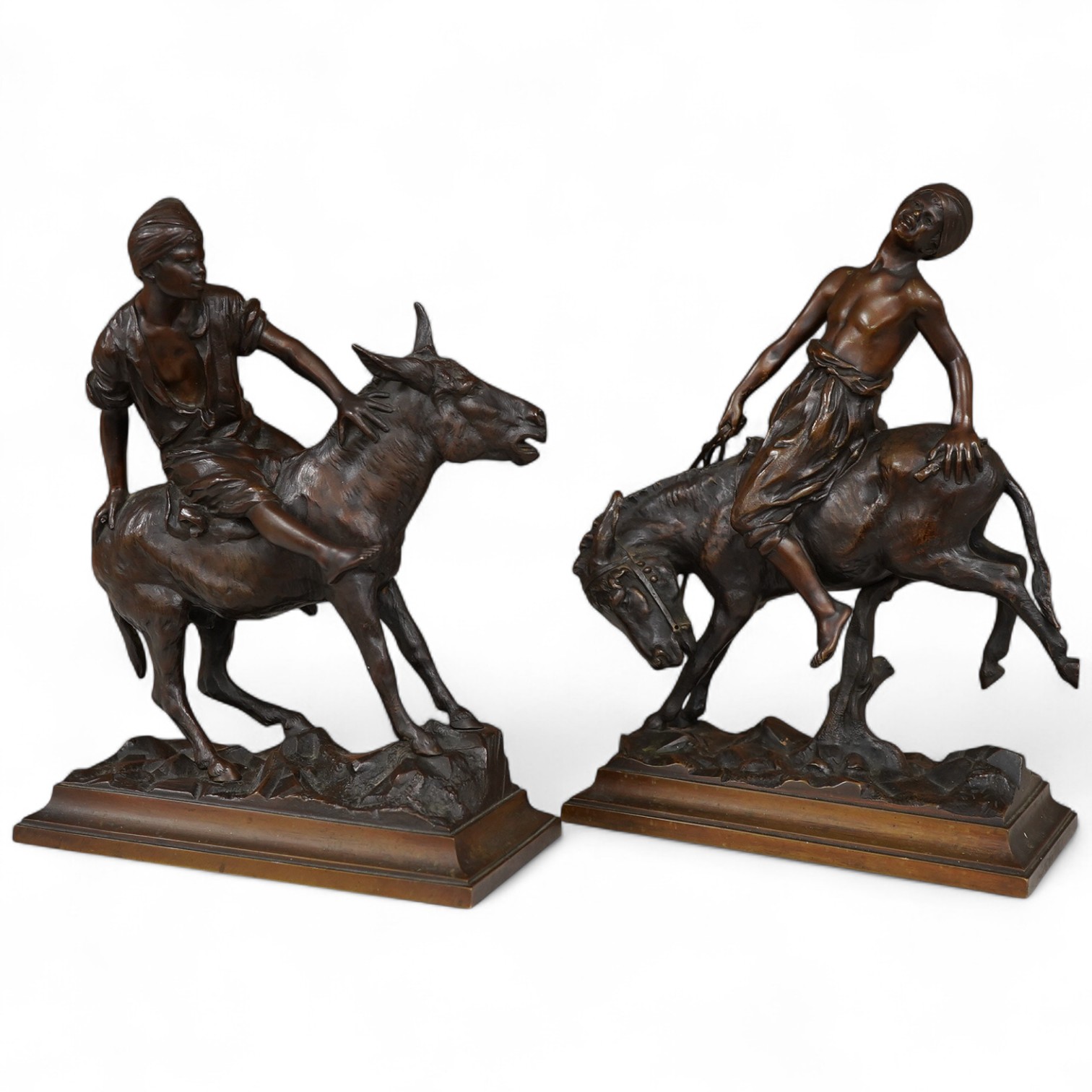 After Paul Aichele (1859-1910), a pair of bronze figures of Arab boys riding donkeys, 23cm